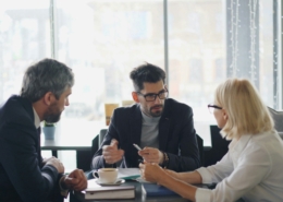 Business meeting with 3 people sitting around a low table